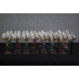 A large collection of stemmed coloured glasses. A mix of light blues, pinks, purple and reds. Mid