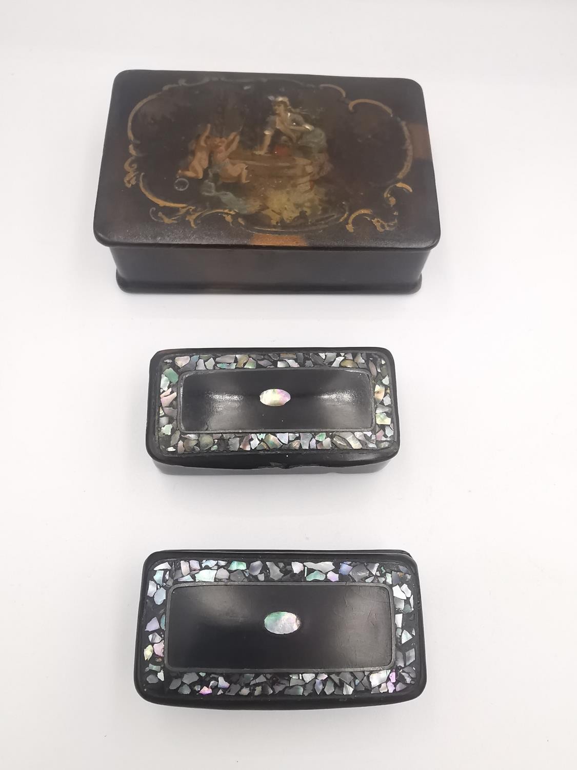 Three 19th century lacquered snuff boxes, one of rectangular form with painted red interior with