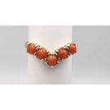 A 9ct yellow gold coral V-shaped ring. Set with five round red coral cabochons in open back claw