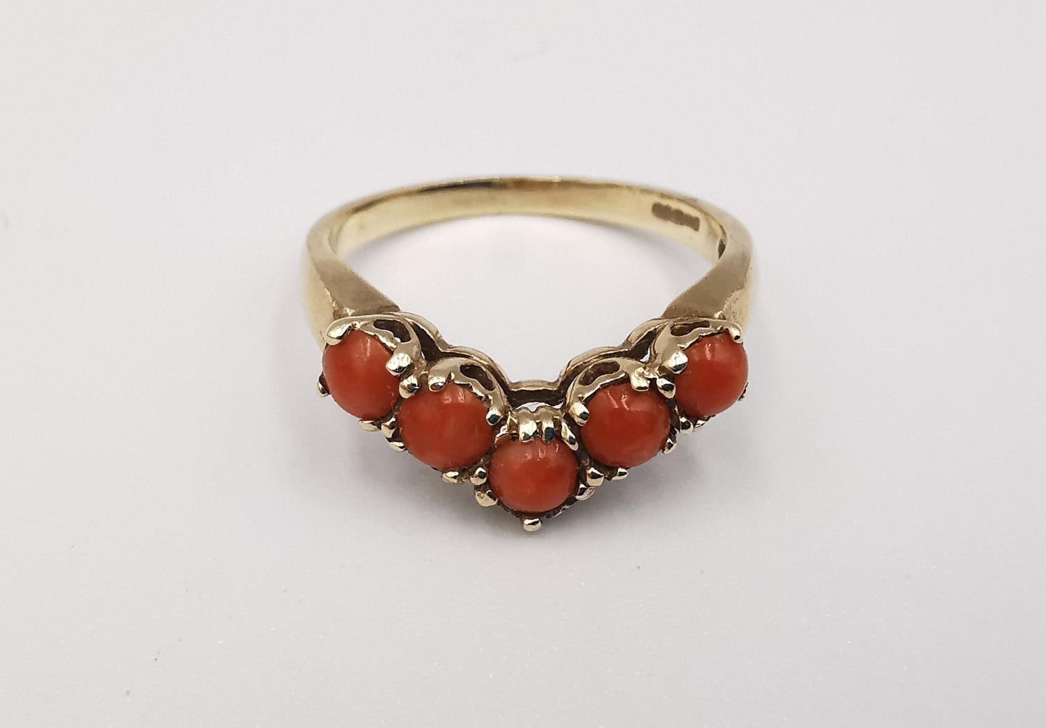 A 9ct yellow gold coral V-shaped ring. Set with five round red coral cabochons in open back claw - Image 2 of 4