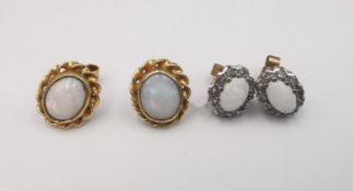 Two pairs of 9ct yellow gold opal stud earrings, one pair with oval opal cabochons in a rope twist