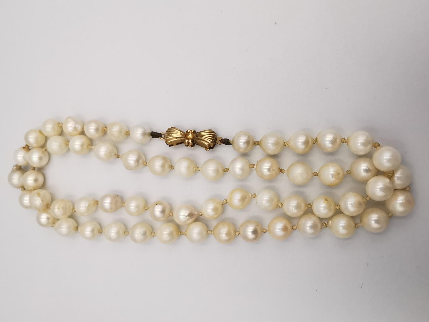 Two knotted white cultured pearl necklaces. One necklace with a 9ct bow shaped hook and push - Image 7 of 10