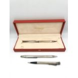 A collection of silver ballpoint pens and pencils, including a red leather cased S. T. Dupont silver