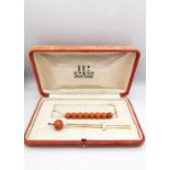 An orange velvet cased early 20th century Kanzashi coral and 14 carat yellow gold hair pin and sting