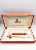 An orange velvet cased early 20th century Kanzashi coral and 14 carat yellow gold hair pin and sting