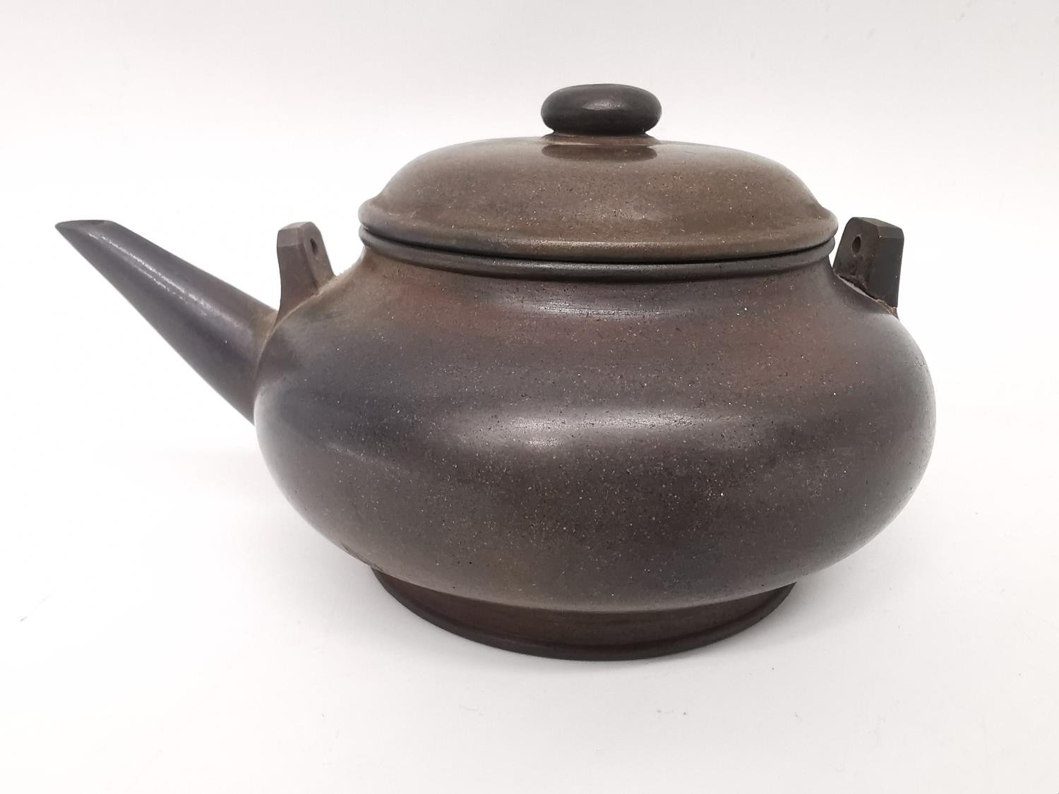 A Qing period Chinese polished Yixing clay teapot of squat rounded form. Impressed character mark to