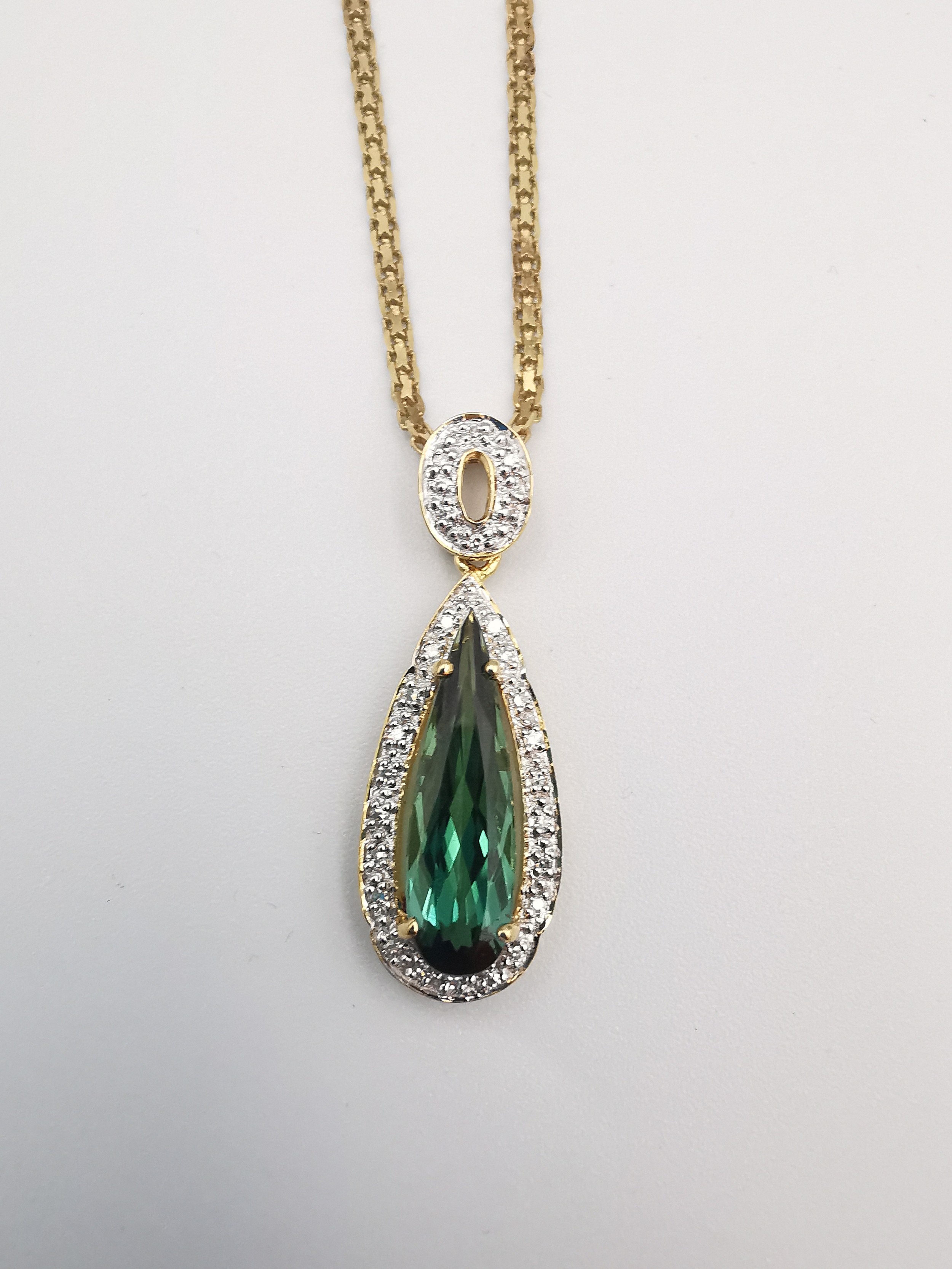 A cased 18 carat diamond and Santa Rosa tourmaline drop pendant on a gold plated silver rope
