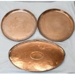 Three large Arts ands Crafts hammered copper trays, one of oval form with twin handles. The pair