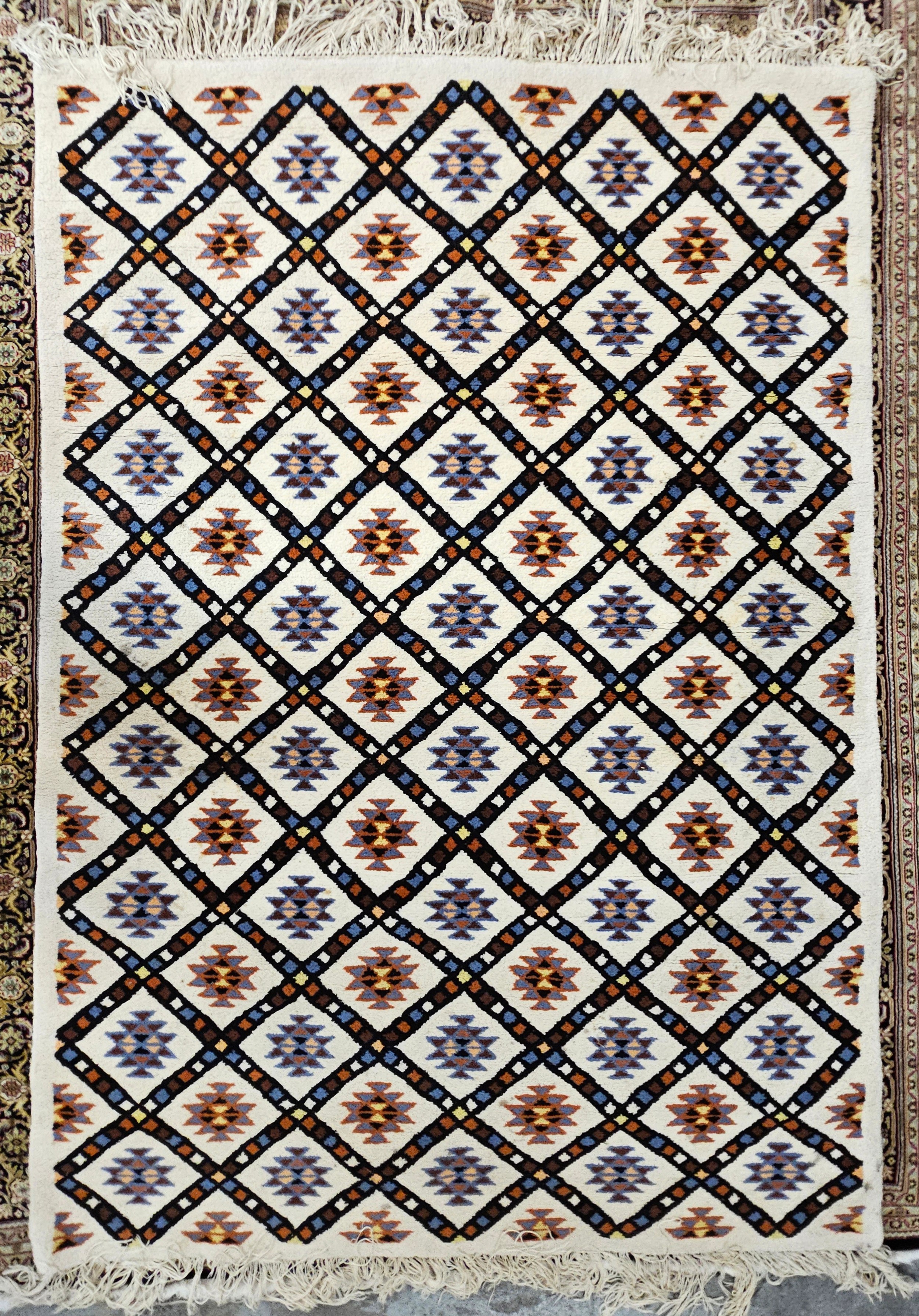 A woollen carpet with allover geometric pattern on an ivory field. L.230 W.195