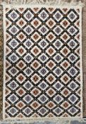 A woollen carpet with allover geometric pattern on an ivory field. L.230 W.195