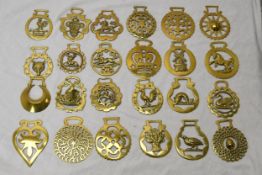 A collection of twenty four early 20th century horse brasses of various designs. x24