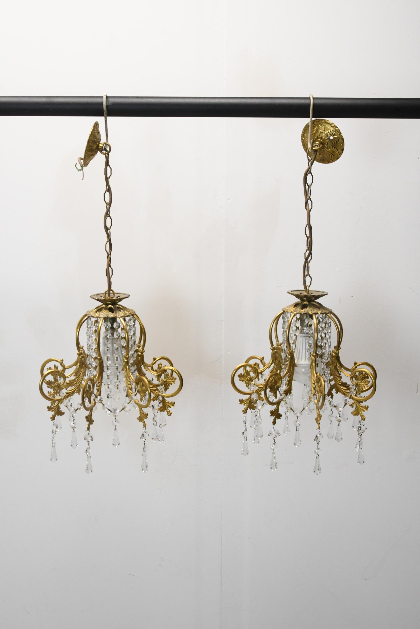 A pair of hanging ceiling lights with scrolling gilt metal frames and crystal drops. H.62 W.30 - Image 2 of 3