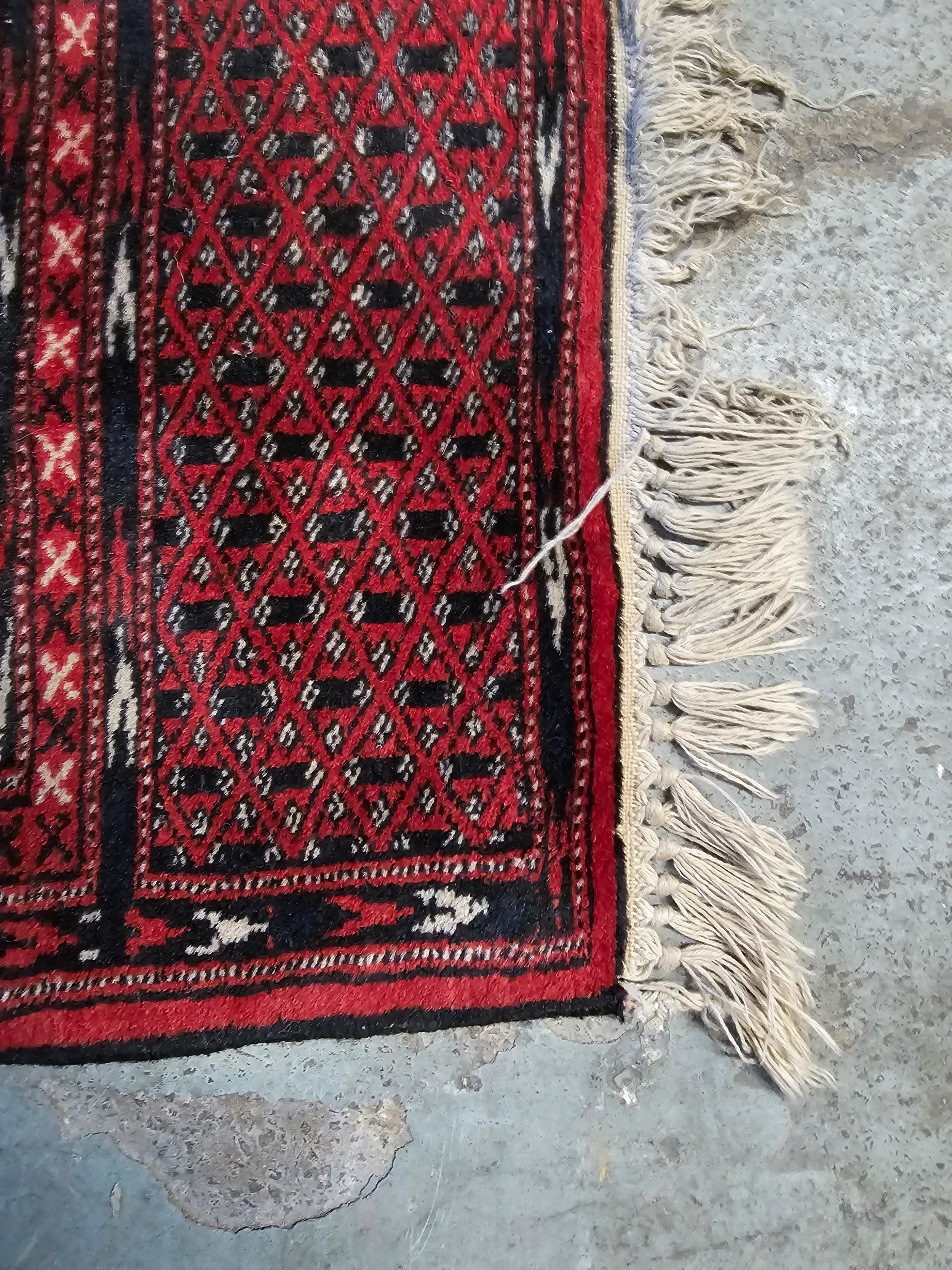 A small Eastern rug with repeating lozenge medallions on a madder field within multiple geometric - Image 2 of 3