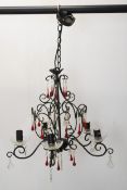 A wrought iron chandelier with five scrolling branches and ruby and cut crystal drops. H.70 W.45