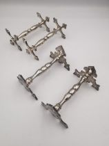 A collection of knife rests, a pair of Victorian silver knife rests with cross design ends by