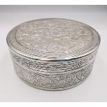 A circular engraved Egyptian silver box, all over decorated with a scrolling stylised foliate