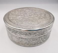 A circular engraved Egyptian silver box, all over decorated with a scrolling stylised foliate