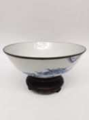 A mid-17th century transitional period Chinese blue and white footed bowl on carved hardwood