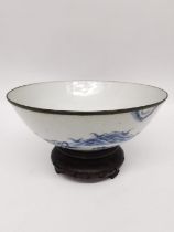 A mid-17th century transitional period Chinese blue and white footed bowl on carved hardwood