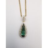 A cased 18 carat diamond and Santa Rosa tourmaline drop pendant on a gold plated silver rope