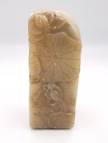 A 19th century carved Chinese soapstone seal with relief lotus leaf, pod and bird decoration. The