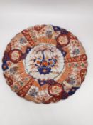 A large 19th century Japanese scalloped edge Imari pattern charger with gilt detailing decorated