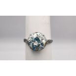 An Edwardian diamond and white metal (tested as platinum) flanked solitaire ring. Set to centre with
