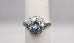 An Edwardian diamond and white metal (tested as platinum) flanked solitaire ring. Set to centre with