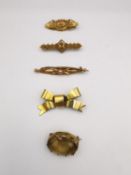 A collection of Victorian gold and yellow metal brooches, including two 15ct Etruscan revival bar