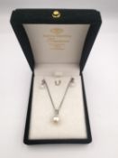 A boxed pair of 9ct white gold pearl and diamond earrings along with a pearl and diamond pendant and