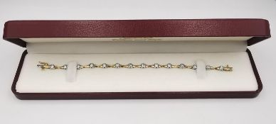 A vintage boxed 14 carat white and yellow gold diamond articulated line bracelet. The bracelet is