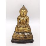 A 19th century carved gilded seated buddha in the lotus position with serene expression. Possibly