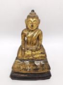 A 19th century carved gilded seated buddha in the lotus position with serene expression. Possibly