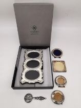 A collection of sterling silver frames and a mirror, including a boxed Carrs silver three picture