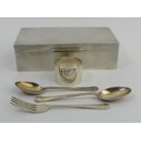 George VI silver cigarette box, two silver spoons, a fork and a napkin ring. Box 17.5 x 9 x 5 cm. UK