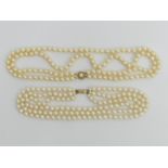 A cultured pearl double strand necklace with a 9ct gold clasp and a faux pearl triple strand example