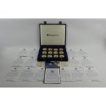 A case of 20 Westminster gold plate and enamel medallions commemorating Queen Elizabeth and Prince