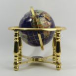 A gilt metal table-top globe with compass inset to the base, 24 cm. UK Postage £14.