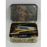 An old tin of various pens and pencils, including Parker examples. UK Postage £12.