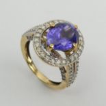 18ct gold oval tanzanite diamond halo ring with diamond set shoulders, 6.5 grams Size N1/2. UK