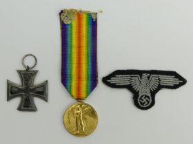 An Iron Cross and a World War I medal to 15032 PTE L Pluckrose W.RID.R and a Nazi cloth badge. UK