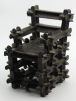 An unusual oriental carved wood lacquered miniature chair which, when shaken, rattles, stamped 1830,