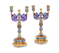 A PAIR OF SILVER GILT AND CHAMPLEVE ENAMEL CANDELABRA IN THE RUSSIAN STYLE