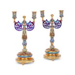 A PAIR OF SILVER GILT AND CHAMPLEVE ENAMEL CANDELABRA IN THE RUSSIAN STYLE