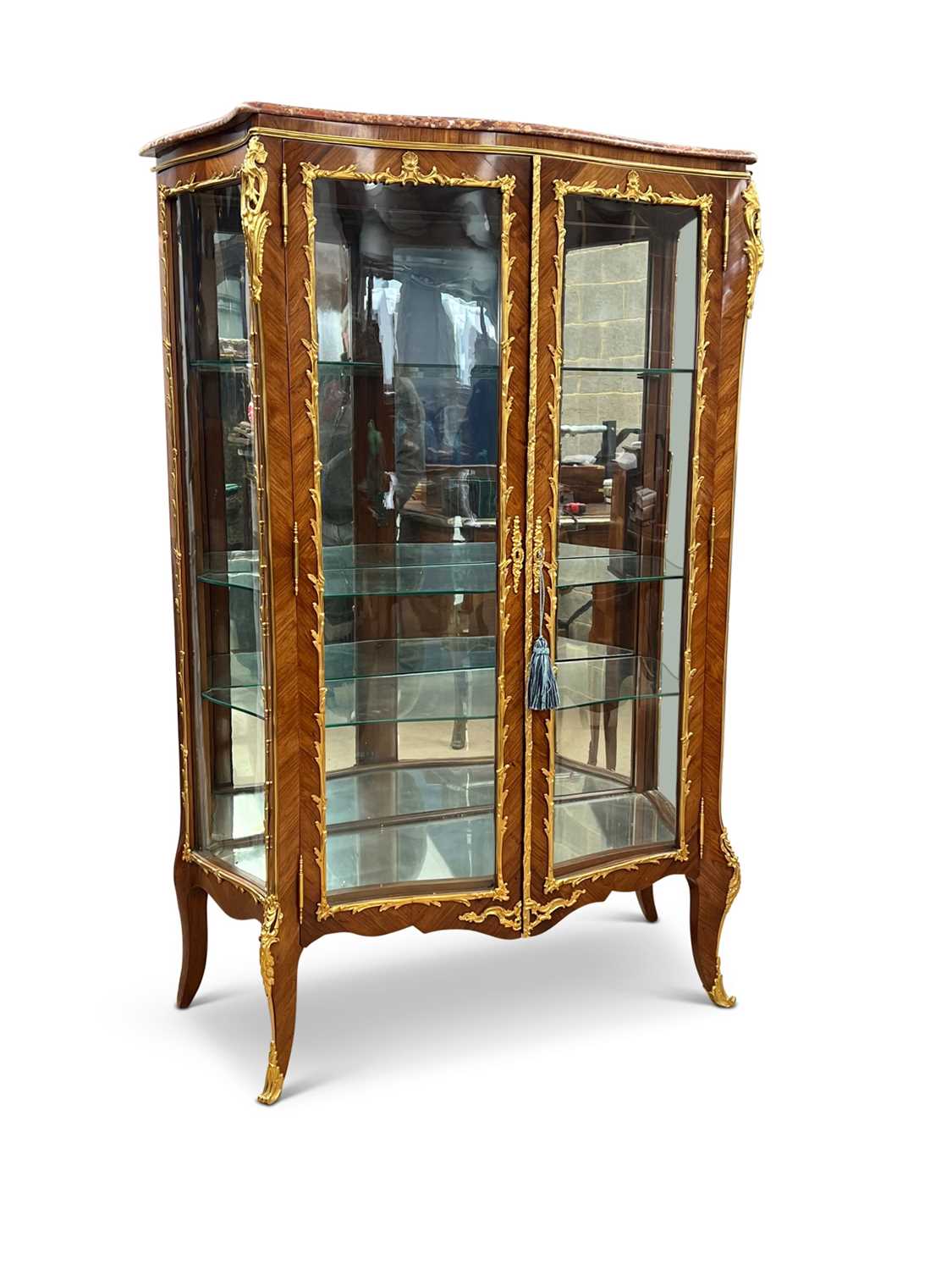 A FINE LATE 19TH CENTURY KINGWOOD AND ORMOLU SERPENTINE VITRINE RETAILED BY JAMES SHOOLBRED