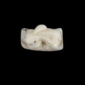 A MINIATURE FOSSILISED MAMMOTH TUSK CARVED NETSUKE OF A RABBIT