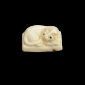 A FOSSILISED MAMMOTH TUSK CARVED NETSUKE DEPICTING A CAT