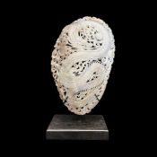 A MOTHER OF PEARL SHELL CARVED WITH DRAGONS