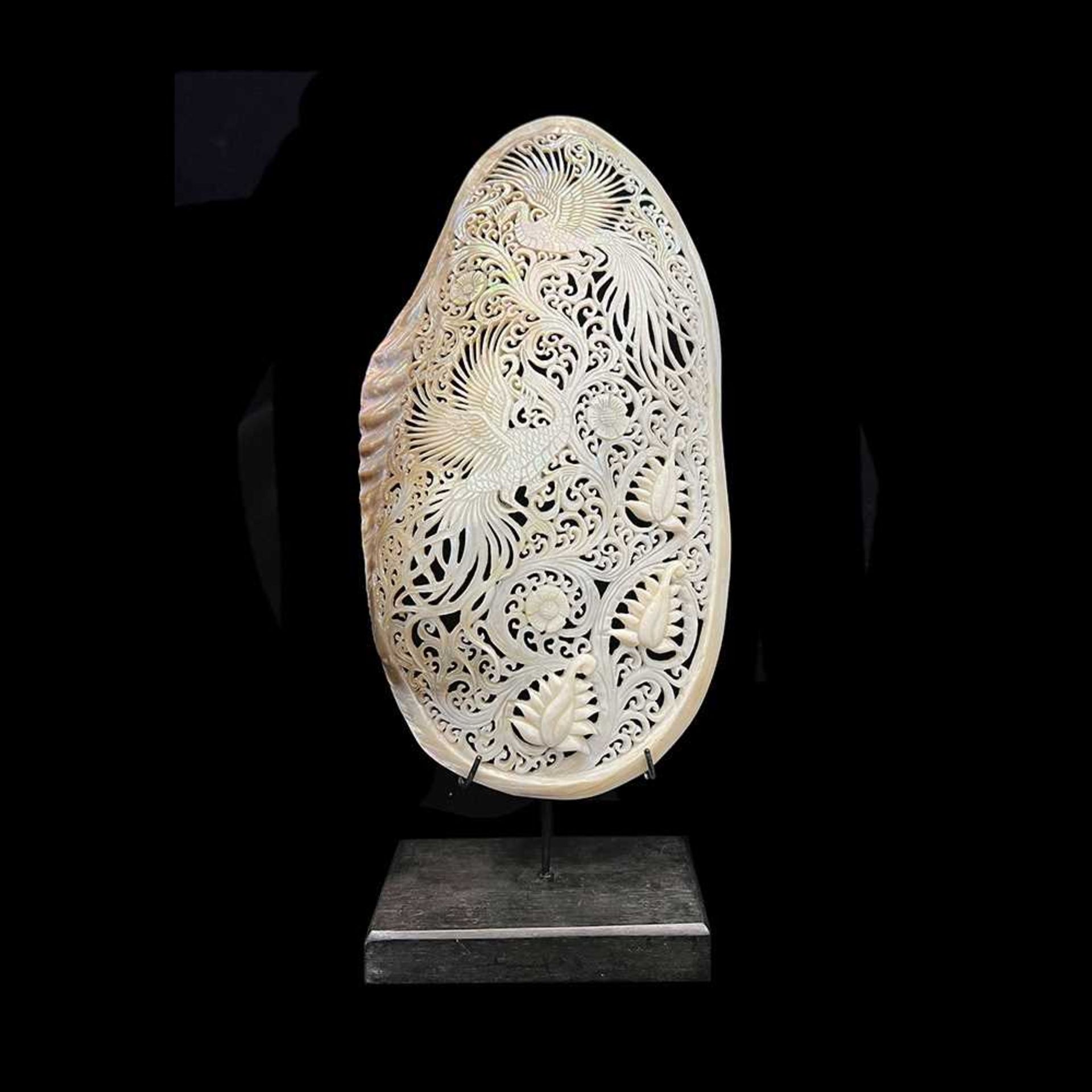 A MOTHER OF PEARL SHELL CARVED WITH A PAIR OF PEACOCKS AND FLOWERS