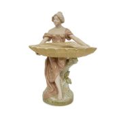 AN EARLY 20TH CENTURY ROYAL DUX BOHEMIA PORCELAIN FIGURE OF A MAIDEN WITH A SHELL